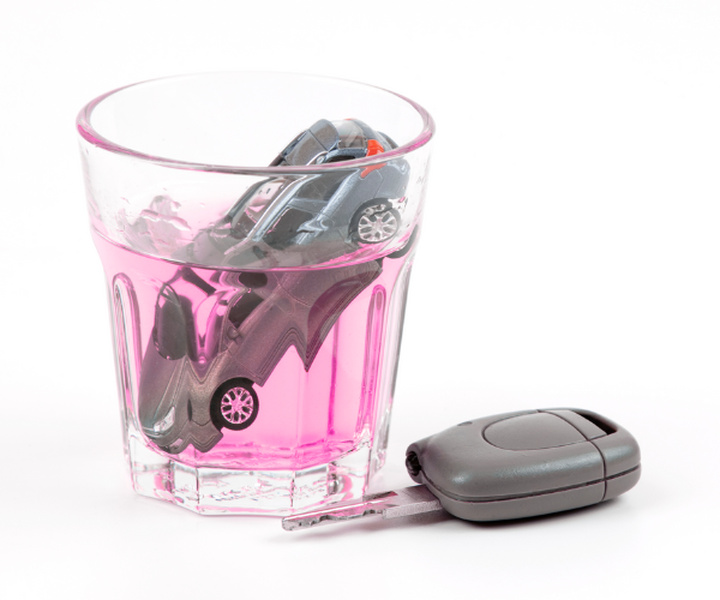 Imagem da miniatura e um carro afogado em um copo com bebida, ilustrando o conteúdo sobre beber e dirigir.