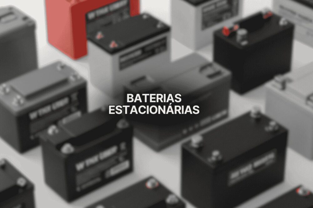 Imagem mostrando várias baterias estacionárias de diferentes tamanhos e cores, incluindo modelos pretos e vermelhos, organizadas em superfície branca, representando opções modernas de baterias estacionárias para diversos usos.