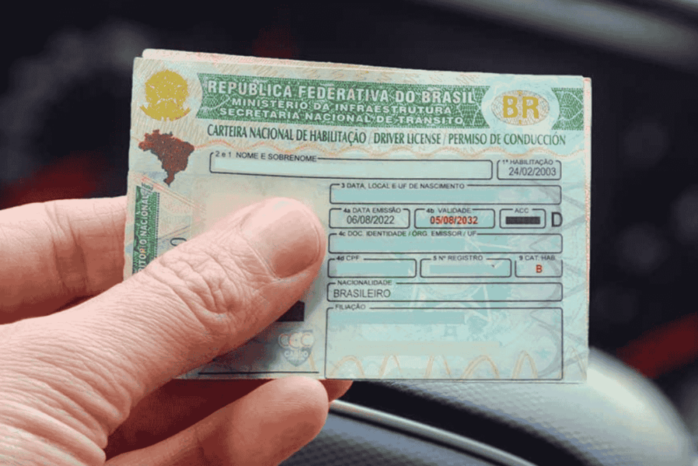 Close-up de uma mão segurando uma CNH brasileira. A imagem ilustra o conteúdo sobre como renovar CNH PE.