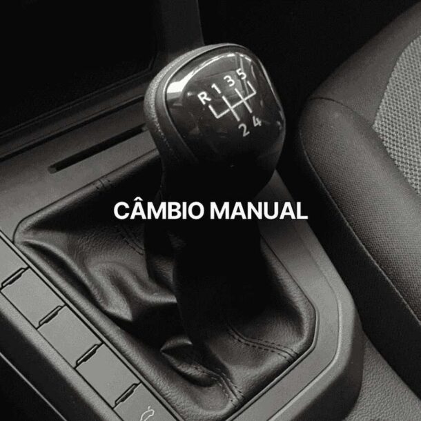 Close no interior de um carro mostrando o câmbio manual com as posições das marchas visíveis, incluindo ré e cinco marchas à frente.