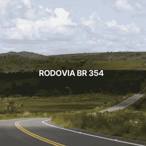 Trecho sinuoso da br 354, com estrada asfaltada de pista simples cortando uma paisagem verde de cerrado e colinas ao fundo, sob céu parcialmente nublado, destacando a rodovia federal em ambiente natural preservado.