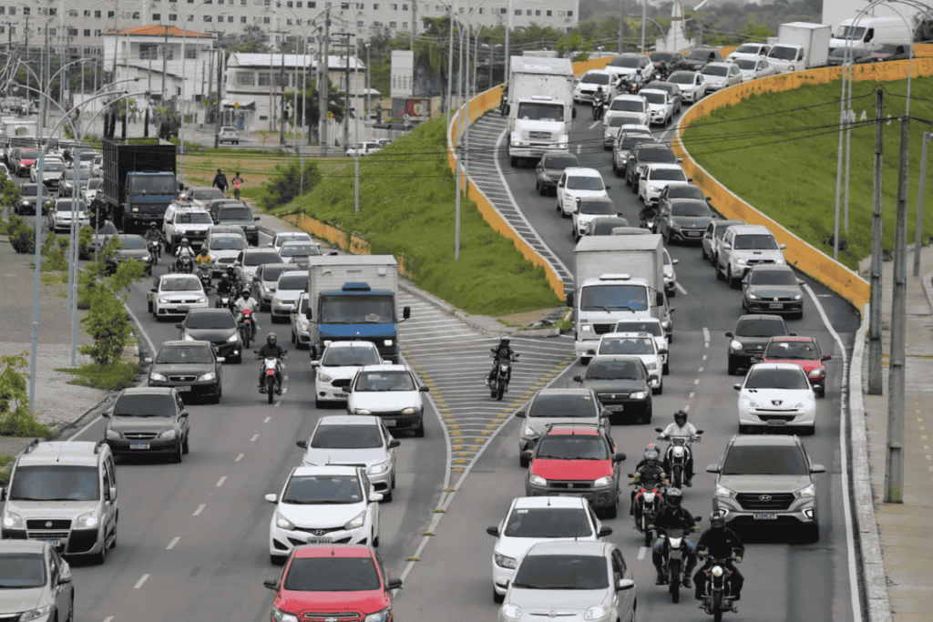 Trânsito intenso em avenida de Fortaleza, Ceará, com carros e motos em horário de pico. Imagem ilustrativa do conteúdo sobre renovar CNH Ceará.