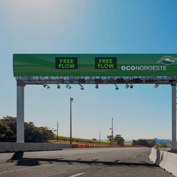 Pórtico moderno de pedágio eletrônico Free Flow em uma rodovia no interior de SP, administrada pela concessionária EconoNoroeste, ilustrando o conteúdo sobre como pagar pedágio free flow em SP. Estrutura verde com painéis escritos “FREE FLOW” e câmeras para leitura de placas, permitindo o pagamento automático sem necessidade de parar o veículo.