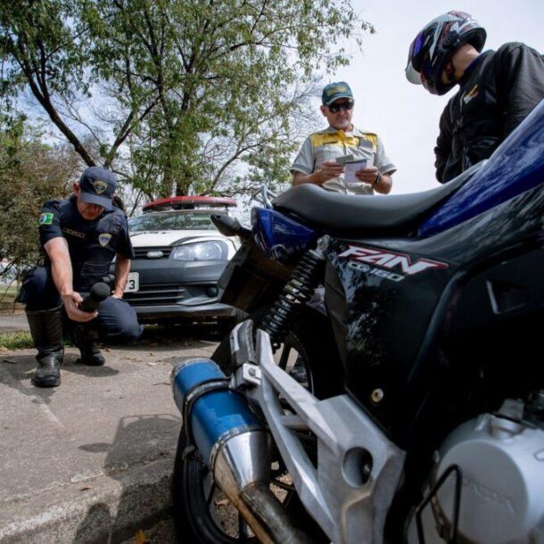 Agente fiscaliza escapamento de motocicleta durante operação contra barulho excessivo.