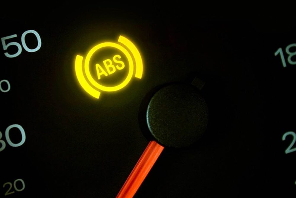Luz amarela do ABS acesa no painel do carro, indicando possível falha no sistema de freios antitravamento.